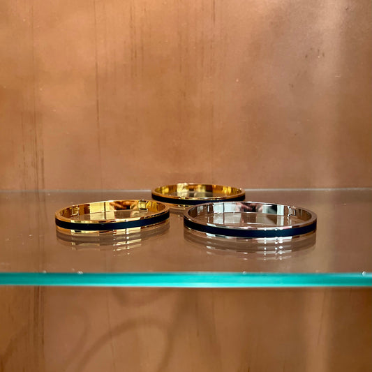 Three metallic rings on a reflective surface with a wooden background